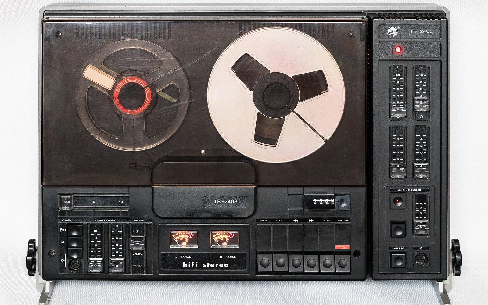 A vintage reel-to-reel tape recorder with dual VU meters and multi-playback control panel